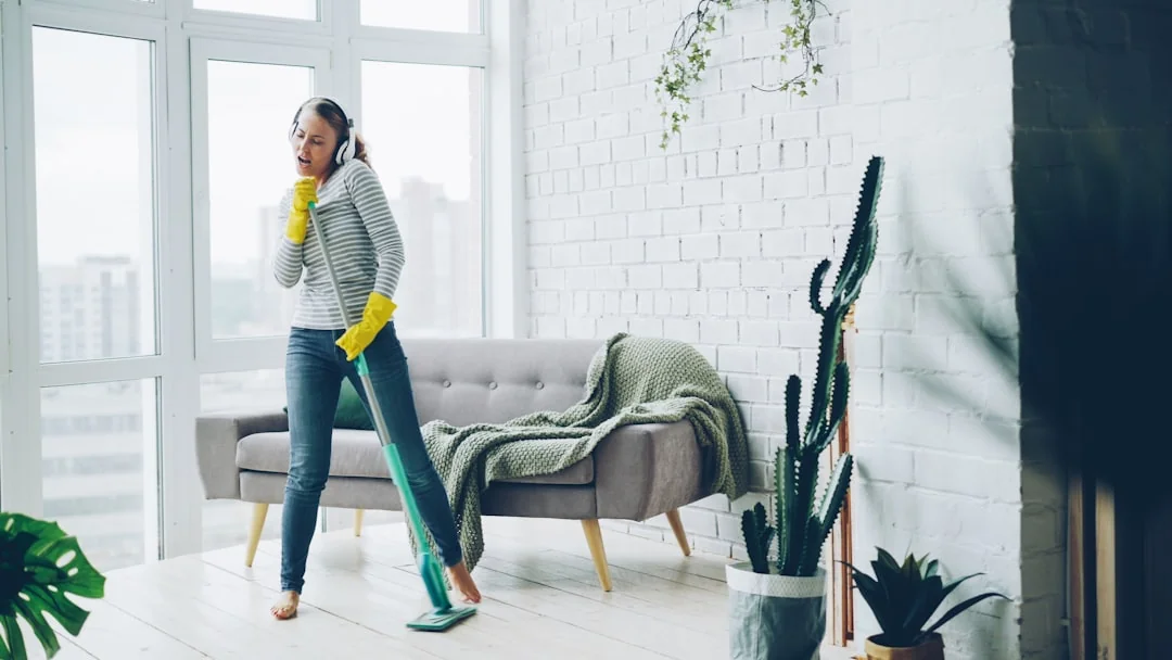 Un couple range son salon, en réorganisant les meubles et les tapis avec esprit d’équipe.